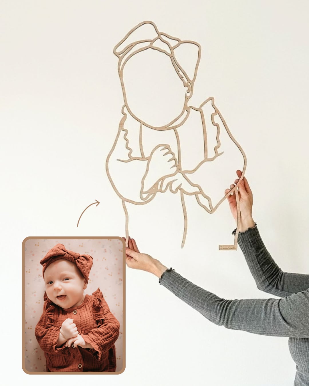 Linienporträt aus Holz eines Babys mit einer Schleife im Haar, neben dem Originalfoto
