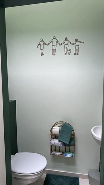 Linienporträt aus Holz einer Familie in der Toilette