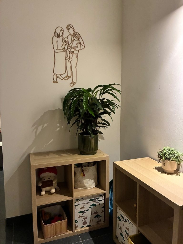 Linienporträt aus Holz einer Familie über einem offenen Regal