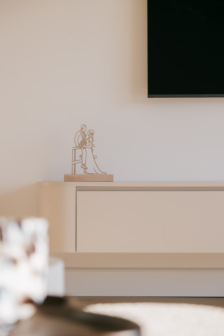 Houten lijnportret op een staander op een licht dressoir