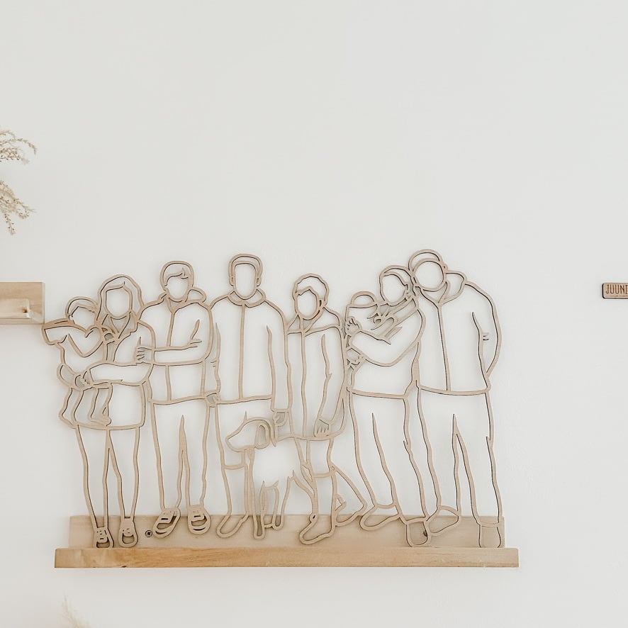 Linienporträt aus Holz einer großen Familie mit ihrem Hund, auf einem Holzregal