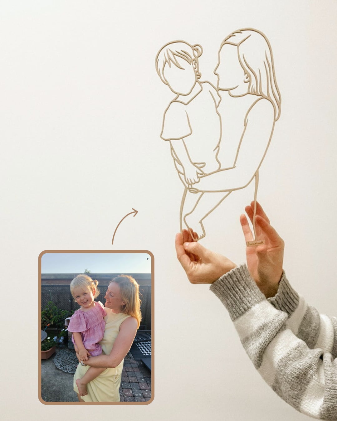 Linienporträt aus Holz einer Mama mit ihrer kleinen Tochter auf dem Arm, neben dem Originalfoto