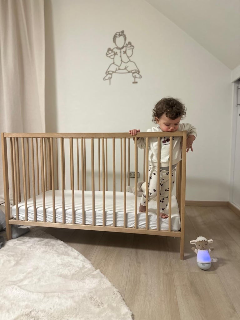 Linienporträt aus Holz eines Babys im Kinderzimmer, über dem Bettchen
