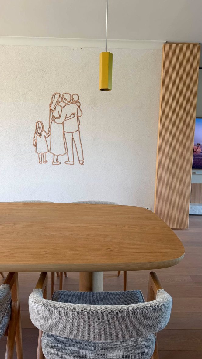 Linienporträt aus Holz einer Familie über dem Esstisch